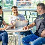 Freelanceris dirba prie nešiojamojo kompiuterio, skaičiuoja valandinį įkainį ir tvarko finansus.